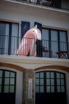Pink flamingo pool float on a modern building terrace