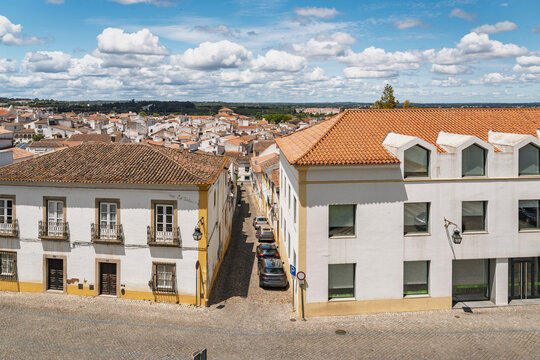 View of the historic streets and traditional white buildings with terracotta roofs in the city center of Evora, Evora District, Portugal.