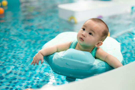 Baby Floating in Pool, touching the water's surface