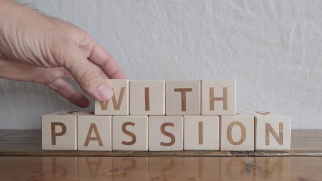 motivational word With passion, laying out by hand from letters on wooden cubes, slow motion
