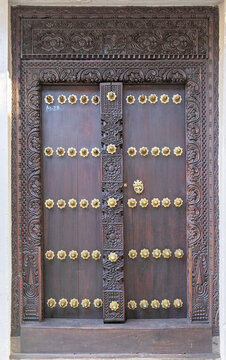 View of an intricately carved traditional wooden door with brass studs in Zanzibar, Mjini Magharibi Regio, Tanzania.