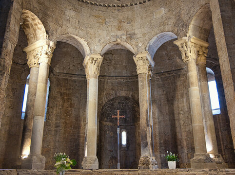Romanesque Church Interior with Stone Columns and Cross