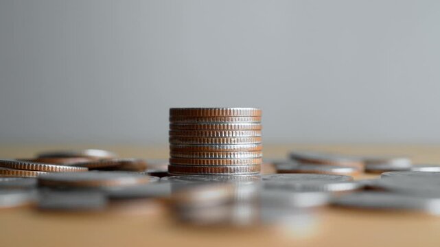 Hand stacking coins on stack for savings and investment concept