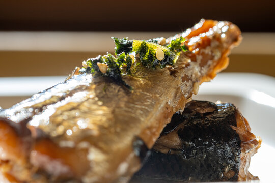 Japanese style simmered marinated fish topped with seaweed and white sesame seeds.
