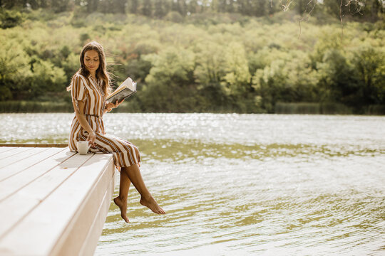 Relaxing by the water with a good book on a sunlit lakeside afternoon
