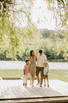 Family enjoying a sunny day by the lake on a wooden dock