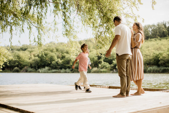 Joyful family moment on a serene dock by the tranquil lake