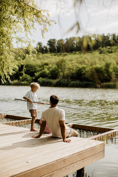 Father and son enjoy a peaceful fishing moment by the riverbank
