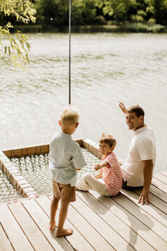 Joyful moments by the serene lake with family enjoying a sunny day