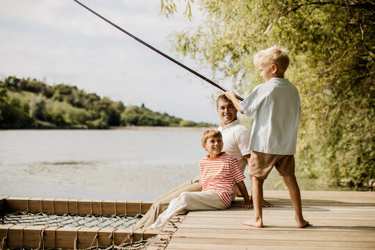 Father and sons enjoying a peaceful fishing day by the riverside