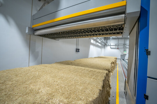 View of industrial machinery processing large bales of fibrous biomass in a factory facility in Berlin, Berlin, Germany.