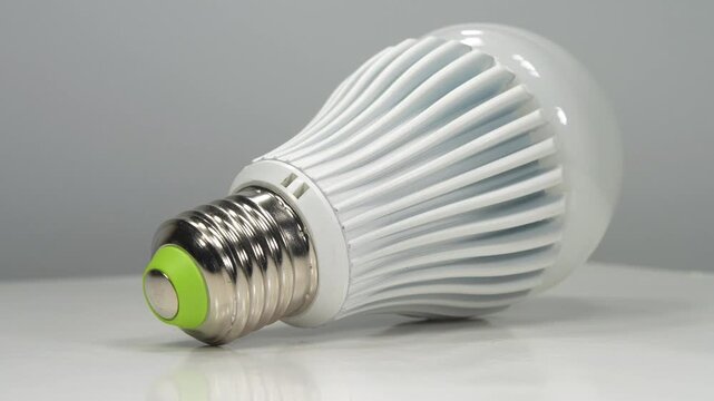 Modern LED bulb featuring an E27 base, isolated against a clean grey background, highlighting its simple design and energy-efficient lighting for everyday use