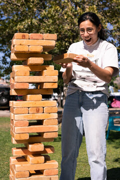Woman reacting with surprise during a wooden stacking game