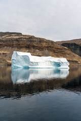 Iceberg in East Greenland floating at sunset in still water © Michael