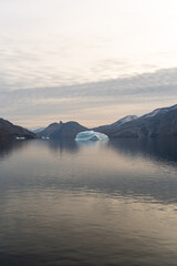 Iceberg in East Greenland floating at sunset in still water © Michael