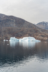 Iceberg in East Greenland floating at sunset in still water © Michael