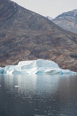 Iceberg in East Greenland floating at sunset in still water © Michael