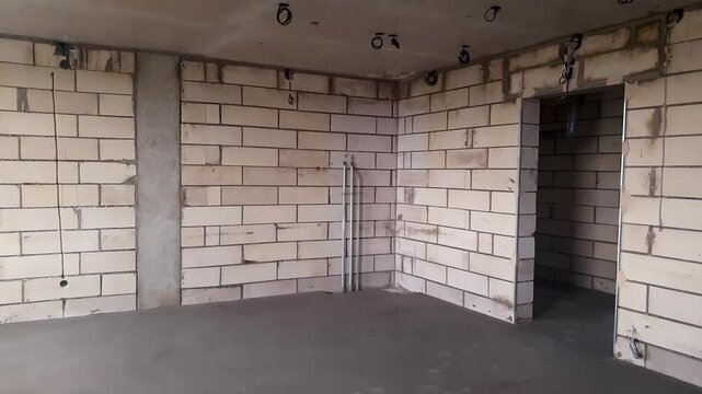 Construction of a room using foam blocks. A completed room an unfinished living space. A room built from gas silicate blocks.