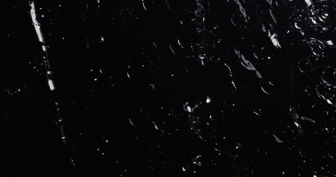 Raindrops Falling on Dark Glass Surface Close Up