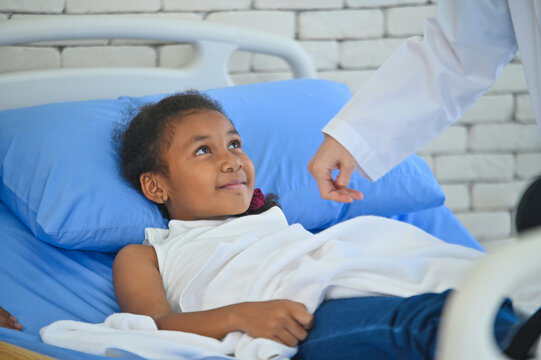 A young girl in a hospital bed smiles at a caregiver, conveying hope and comfort in a medical setting. The atmosphere highlights care and compassion.