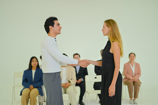 Engaging moment between two individuals shaking hands, symbolizing connection and collaboration in a professional or social setting.