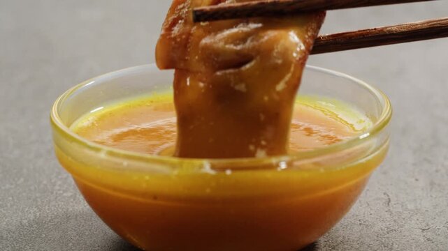 Curry cheese lemon sauce close up, fast food cafe Pouring fries potato and fry chicken in mayo yellow creamy cheese sauce close-up. Eat chicken nuggets with Peruvian sauce. Fast and junk food concept.