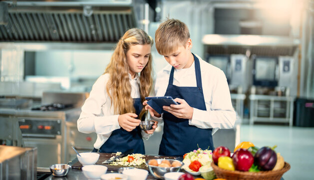 Young chef cooking at restaurant kitchen.