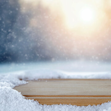Empty wooden board with copy space in snowy winter landscape &ndash; seasonal product concept.