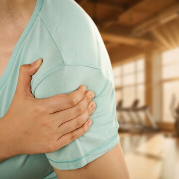 Woman stretching and massaging painful body areas of arm&ndash; muscle pain and health concept.