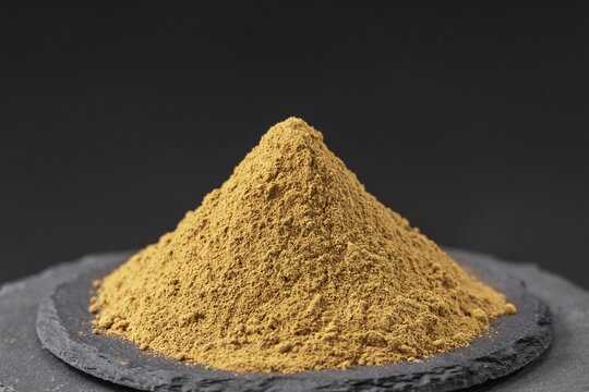 dried basil leaves powder from the plant ocimum basilicum on a black slate stone tray