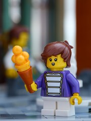 Fototapeta premium Tambov, Russian Federation - June 24, 2026 A close-up shot of a Lego child minifigure with an orange ice cream cone
