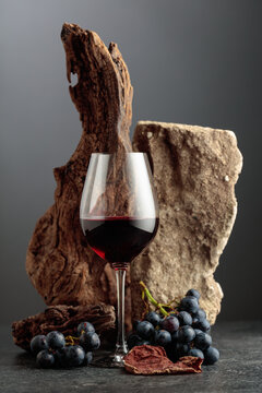 Red wine with stone, dried snags, and blue grapes.