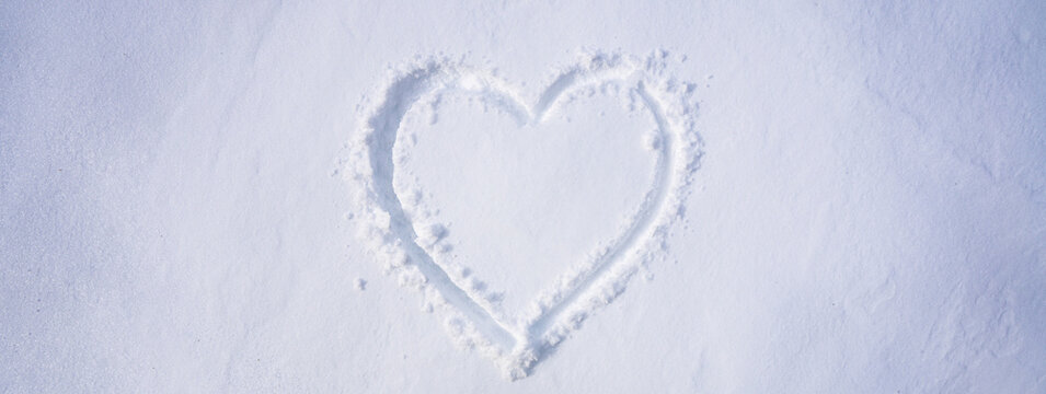 Snow heart. Romantic winter scene. Winter heart background. Snow heart symbol in snowy field.