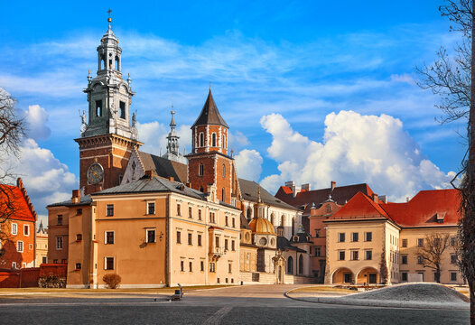 Wawel castle in Krakow, Poland. Panoramic view. Towers of Catholic temple. Picturesque territory and buildings architecture. Winter day with evening warm sunshine lighting. Sky dramatic clouds.