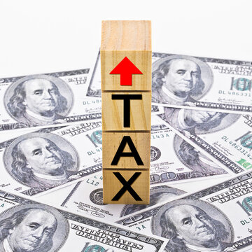 TAX GROWTH CONCEPT with text and arrow written on wooden cubes and US Paper