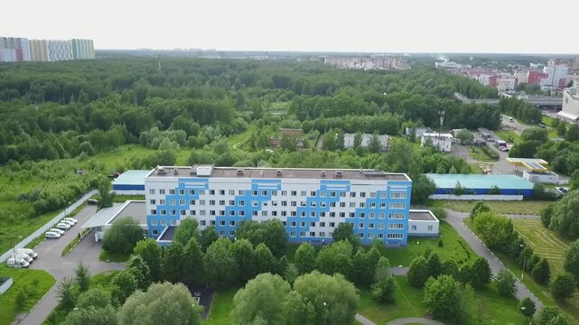 Sideways aerial of blue hospital in Khimki woods