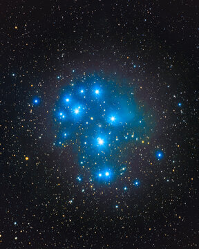 The Pleiades open star cluster Messier 45, also called the Seven Sisters, hot blue stars wrapped in a faint blue reflection nebula in the constellation Taurus