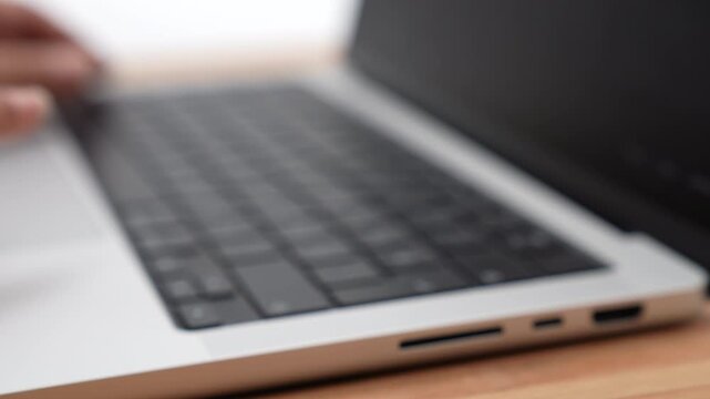 Close-up of a person typing on a laptop keyboard against a clean white background. This high-quality 4K footage captures hands writing, coding, or working remotely, making it perfect for technology