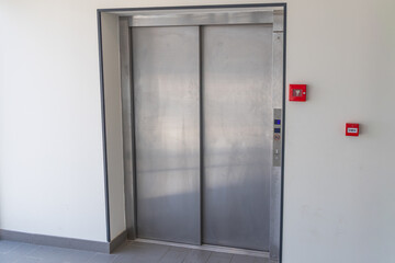Modern elevator doors with brushed metal finish and control panel © AlgarveVisuals