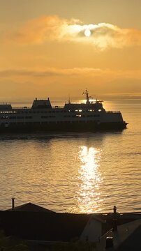 Ferry at sea at dawn. Washington state ferry leaving Whidbey Island at sunrise. Vertical design in 9:16 ratio. Smartphone and social media ready.