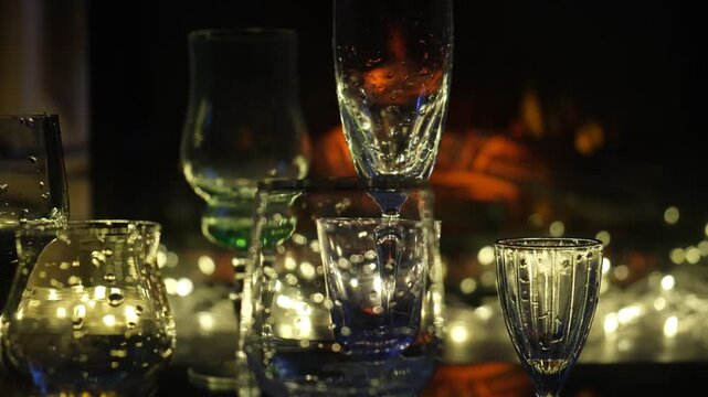 Empty champagne flutes and festive cocktail glasses are elegantly arranged on a beautifully set table, poised for the perfect holiday toast. Warm golden glows