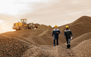 Two industrial miner workers inspecting gold open pit mine at sunset for site inspection © Parilov
