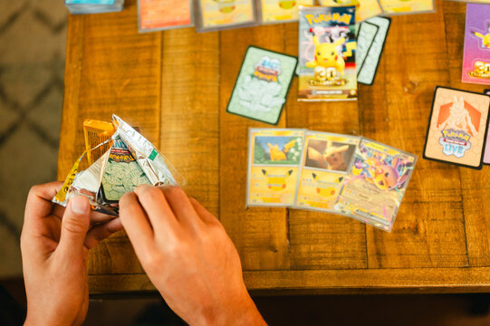 Chicago, IL/USA - September 19, 2026: opening Pok&eacute;mon 30th anniversary celebration booster pack with Pikachu cards on table