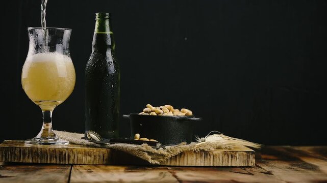 Pouring Cold Beer into Glass with Peanuts on Rustic Table