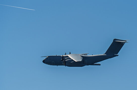 Airbus A400M Atlas military transport airplane flying across a clear blue sky, demonstrating its powerful engines and tactical capabilities for global defense and strategic airlift missions