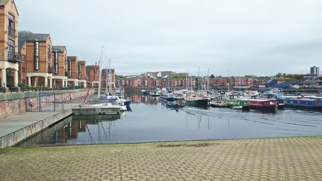 Small boat cruising on Liverpool Marina near Coburg Wharf