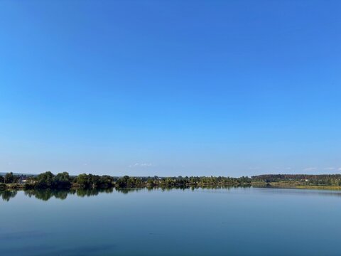 Tranquil Waterscape of Quarry Lake Under Clear Blue Sky