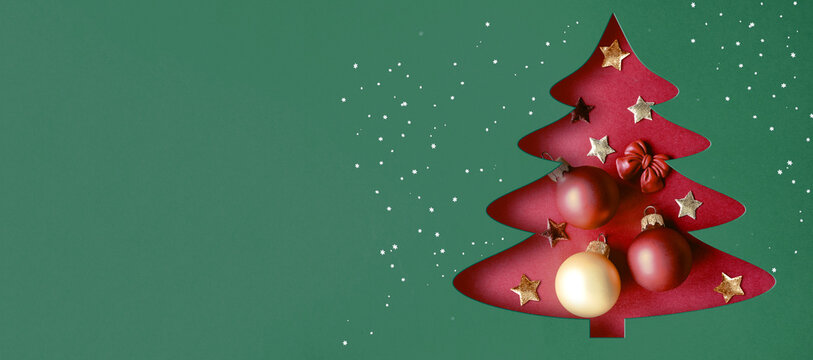 Paper christmas tree with gold star topper and metallic ornaments isolated on a transparent background.