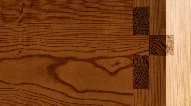 Woodworking detail showcasing through mortise joint in Douglas fir with visible tenon ends and warm amber grain