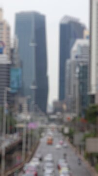 Bokeh view of road traffic in Silom district, Bangkok, Thailand. Blurred background vertical footage.